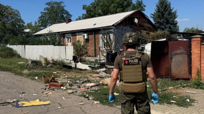 Правоохоронець стоїть у Покровську біля зруйнованого ворожим обстрілом будинку