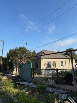 Одноповерховий будинок та забор, які пошкодило обстрілом з боку окупантів.