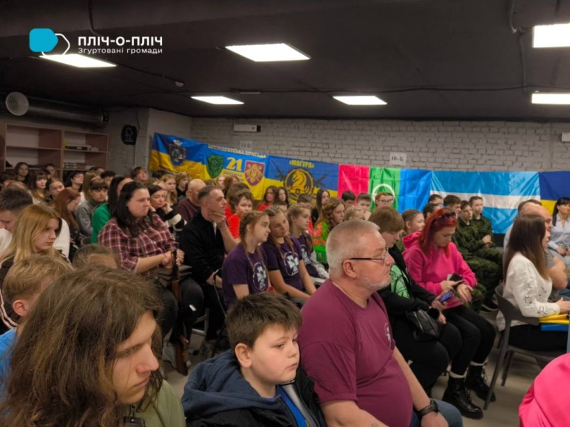 Учасники зустрічі сидять у залі.