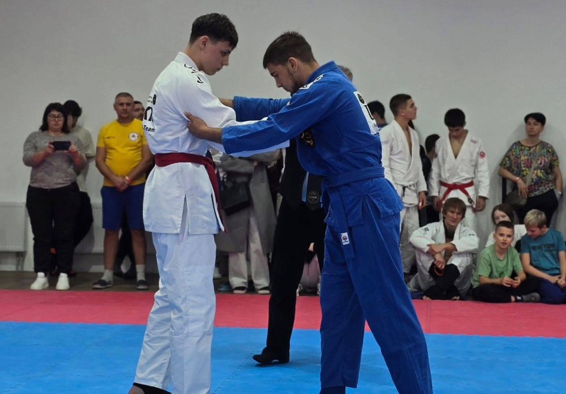 Боротьба спортсменів. Спортсмени на рингу у спортивних костюмах.