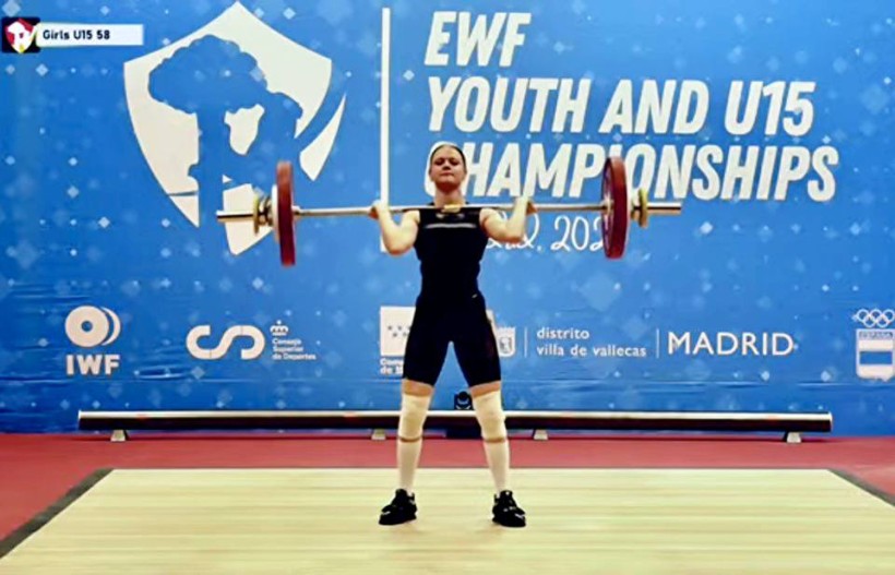 Спортсменка піднімає штангу
