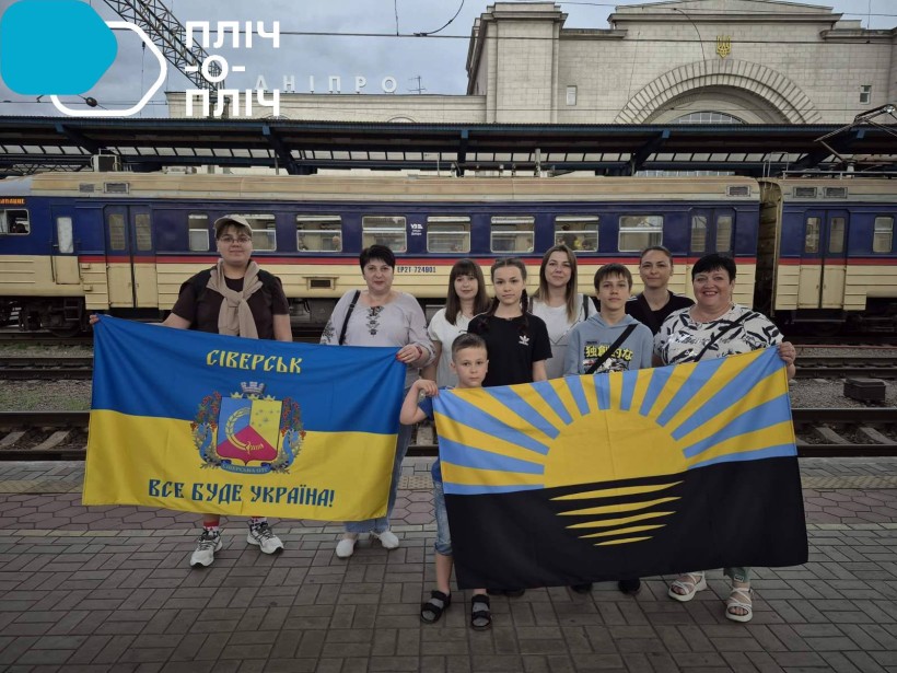 Діти Сіверської громади в Дніпрі на вокзалі біля потяга, на якому відправляться до Закарпаття. Тримають у руках прапори Донеччини та Сіверська.