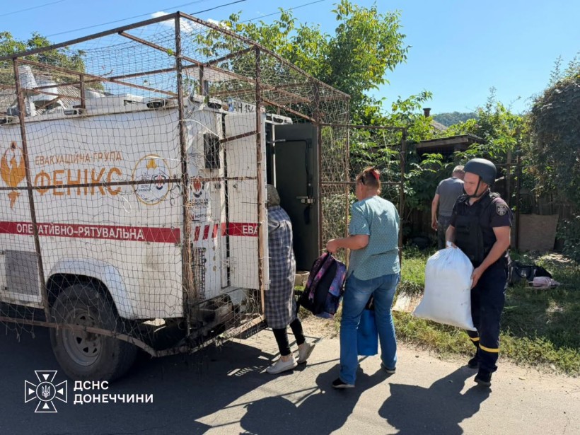 Люди вантажать речі до евакуаційного автомобіля групи "Фенікс"