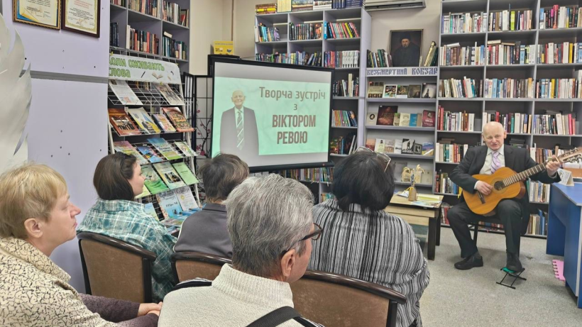 Поет та музикант Віктор Рева грає на гітарі для гостей бібліотечного простору Покровської громади