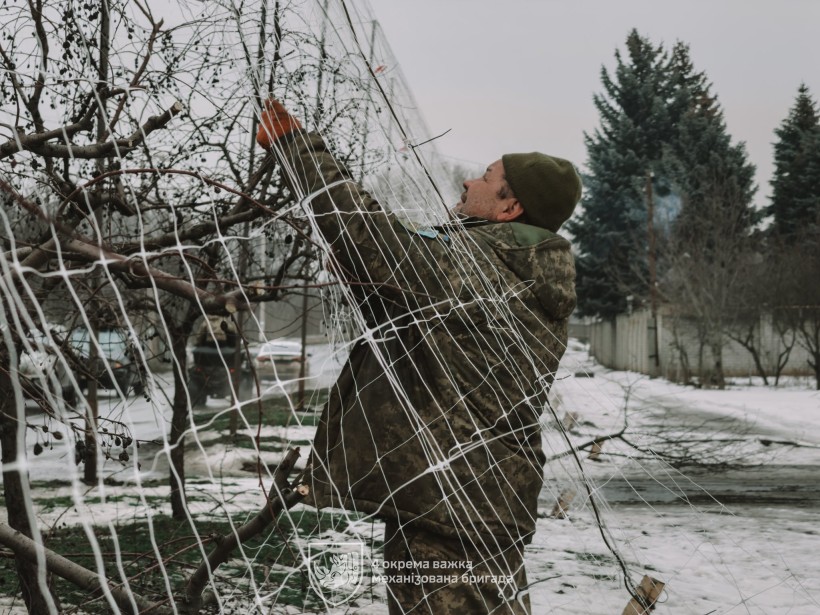 Бійці 4-ї механізованої бригади зводять антидронові сітки над населеним пунктом Донеччини