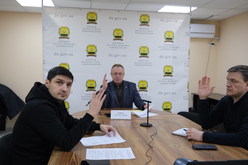 Члени комісії голосують, руки тримають вгору.