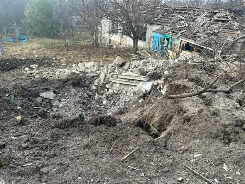 Зруйнований будинок та вирва на місці ворожого обстрілу