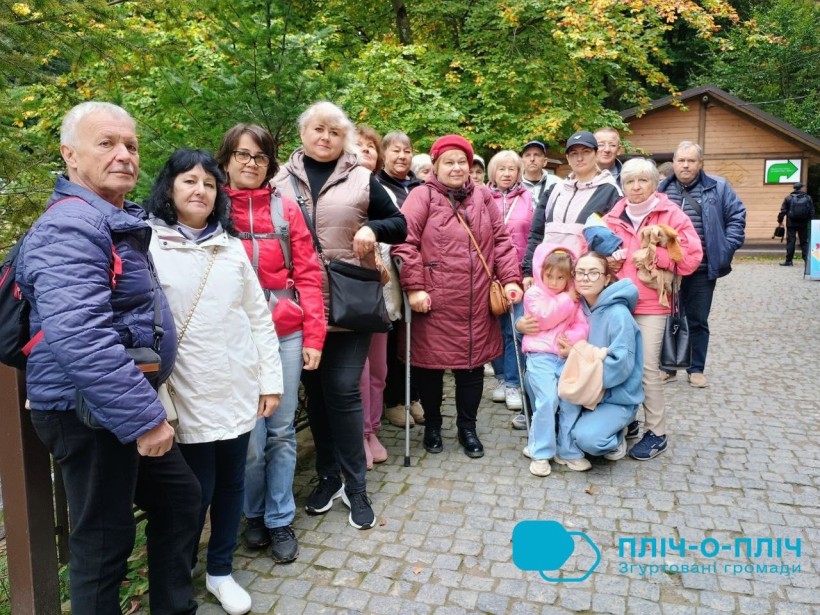 Спільне фото, чоловіки та жінки стоять біля підніжжя гори.