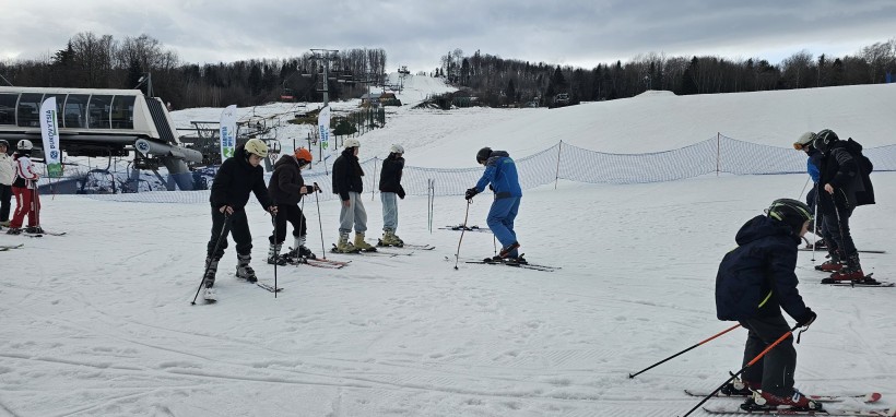 Діти з Селідівської громади на гірськолижному курорті «Буковиця», стоять на лижах та слухають інструктора.