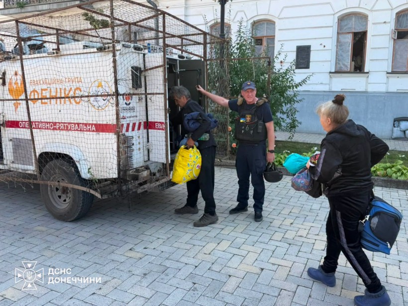 Рятувальник допомагає родині завантажити речі