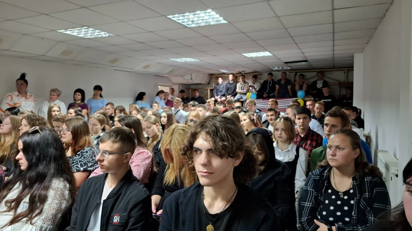 Випускники та педагогічний колектив Бахмутського центру ПТО уважно слухають виступ військовослужбовців 61 окремої Степової механізованої бригади під час патріотичного заходу з нагоди завершення навчального року.