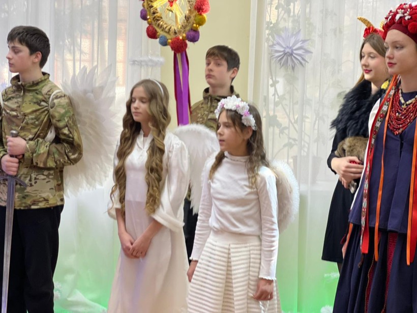 Учасники заходу у святкових костюмах розігрують Різдвяний вертеп.