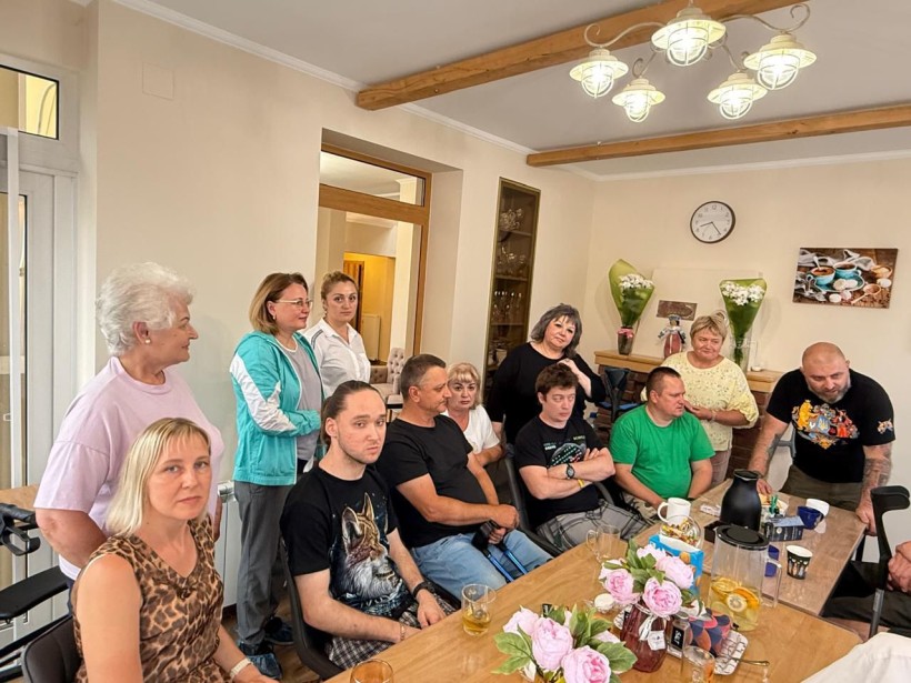 Пацієнти центру з членами робочої групи у приміщенні центру за столом