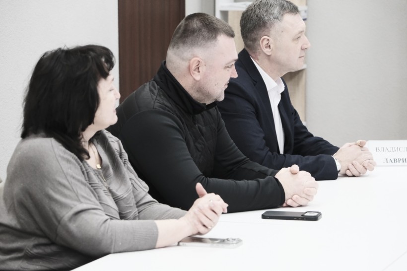 Представники громад, сидять за столом.