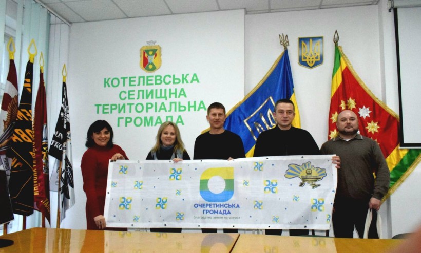 Представники громад-партнерів тримають прапор Очеретинської громади