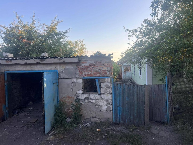 Гараж та ворота, пошкоджені ворожим обстрілом.