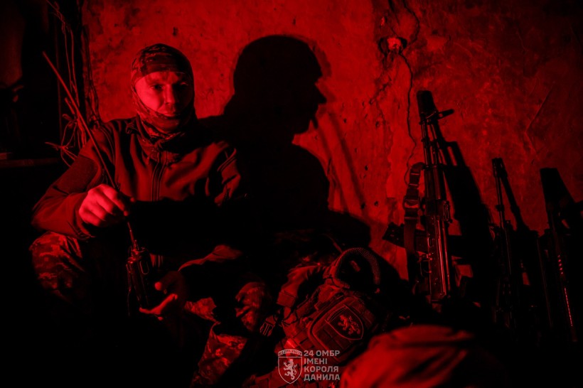 Ніч. Військовий в окопі, поруч зброя.