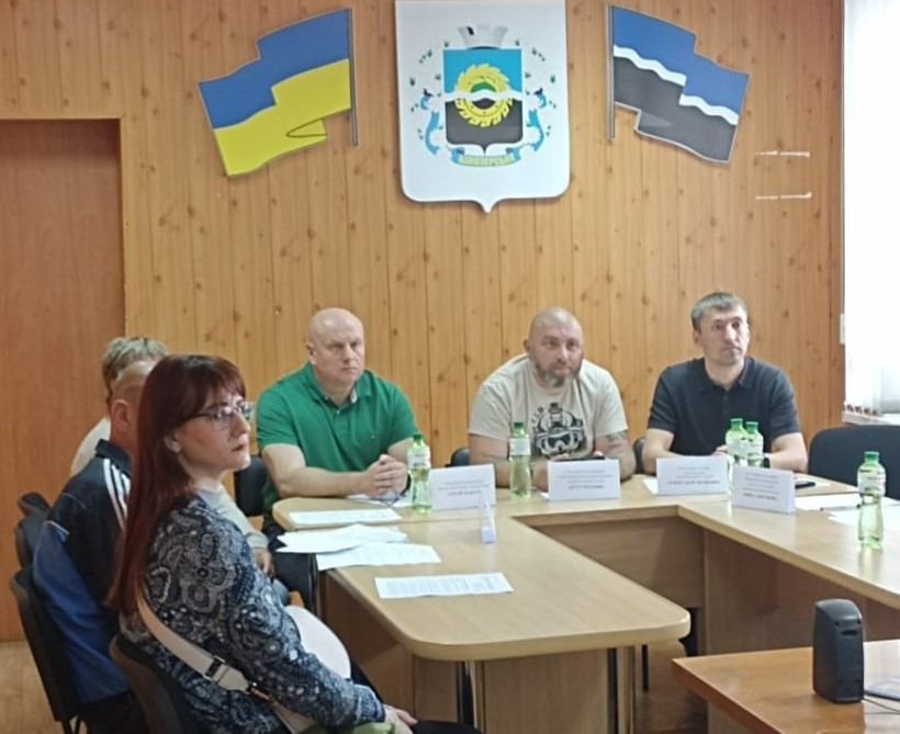 Учасники зустрічі зосереджено стежать за доповіддю про доступ до послуг для ветеранів