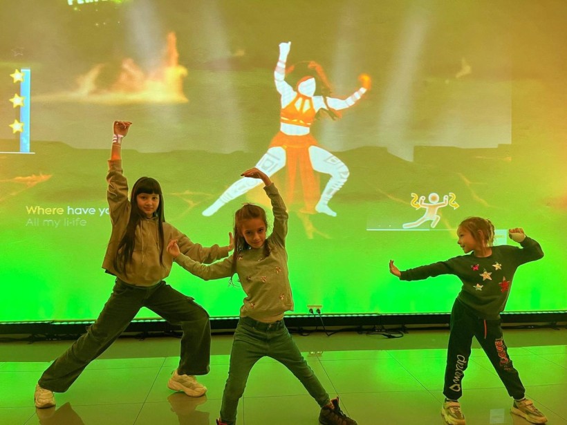 Дівчата повторюють танцювальні рухи з екрана