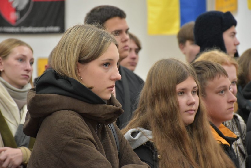 Глядачі уважно дивляться картини, представлені на виставці