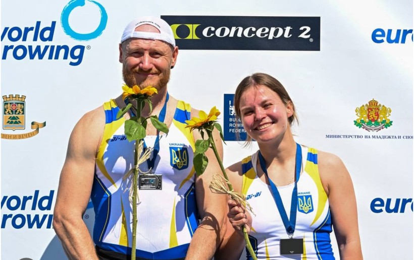 Призери чемпіонату у майках з синьою-золотими стрічками. Тримають соняшники. На задньому плані логотипи спонсорів