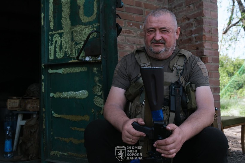 Віськовий сидить з автоматом