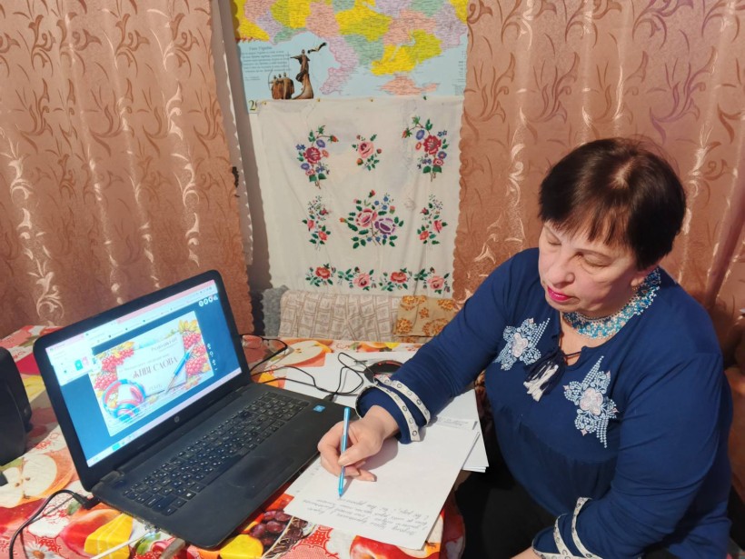 Учасник акції пише диктант перед екраном ноутбука