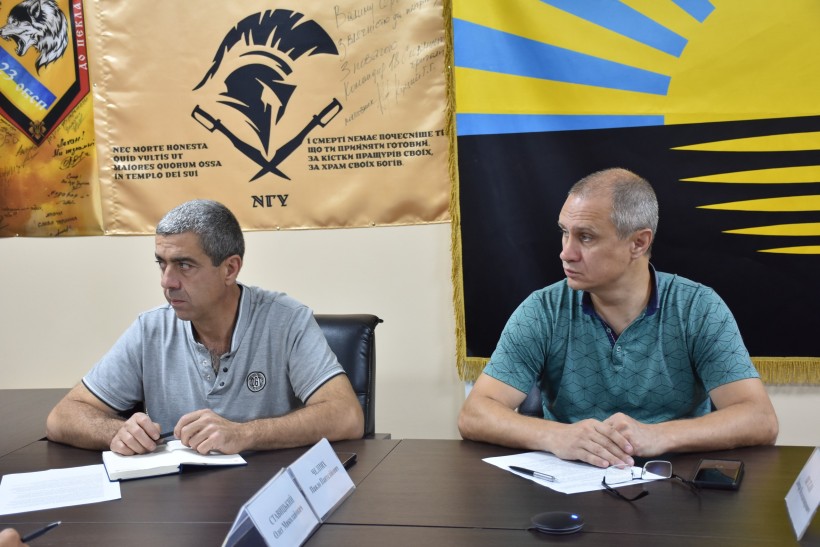 Двоє учасників засідання. Уважно слухають доповідача.