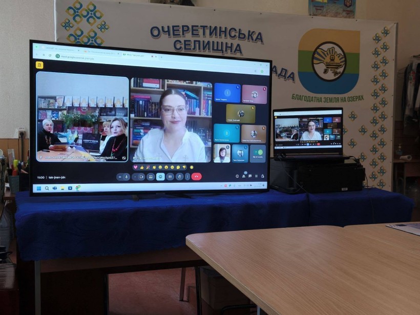 Великий монітор, де відбувається онлайнова зустріч представників громад з поетесою. Позаду - банер Очеретинської селищної громади