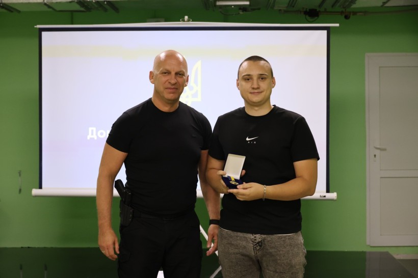 Вадим Філашкін вручає медику нагородний знак.