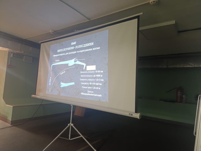 Під час тренінгу інструктор демонструє на великому екрані зображення дрона,