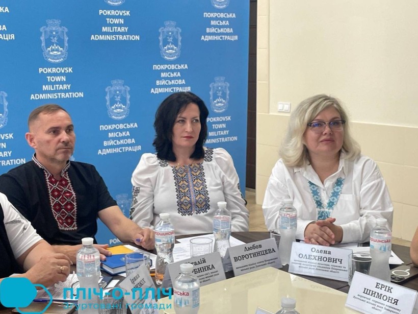 Представники Донеччини, учасники делегації. Сидять за столом, жінки та чоловік одягнені у вишиванки.