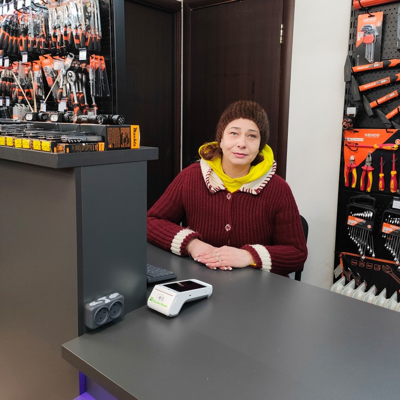 Співробітниця магазина сидить за касою