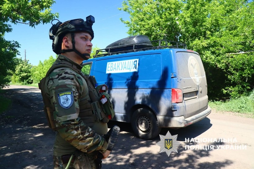 Поліцейсьий чатує на ворожі дрони під час евакуації