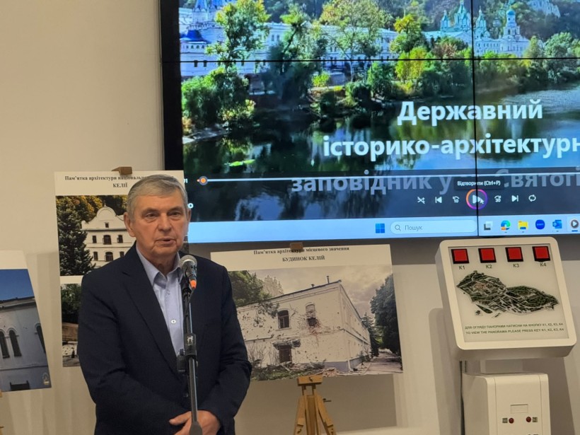 Учасник заходу говорить у мікрофон на тлі фотографій та екрана