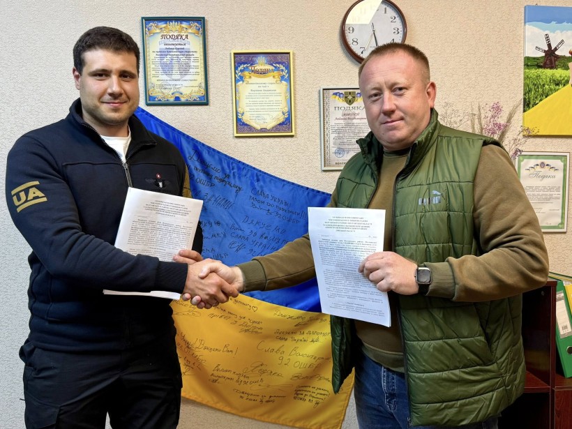 Начальник Хлібодарівської сільської військової адміністрації Михайло Бурнадзе та селищний голова Машівської селищної ради Сергій Сидоренко тримають підписаний меморанду про співпрацю