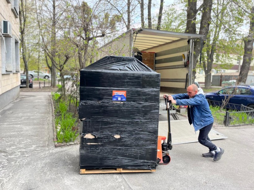 Передача гуманітарної допомоги: чоловік розвантажує вантажівку