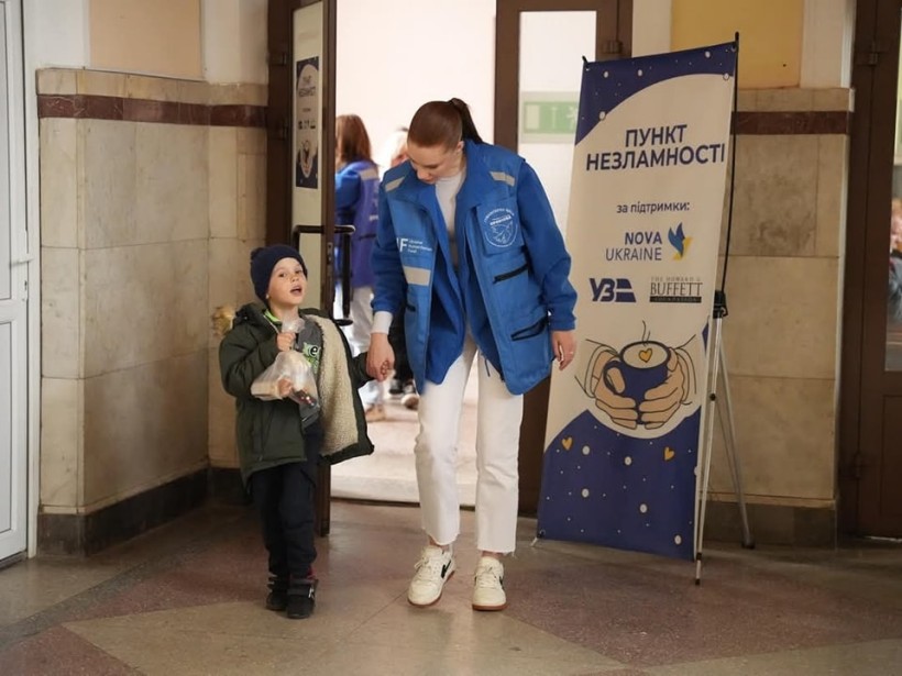 Представниця "Проліски" веде дитину до пункту незламності