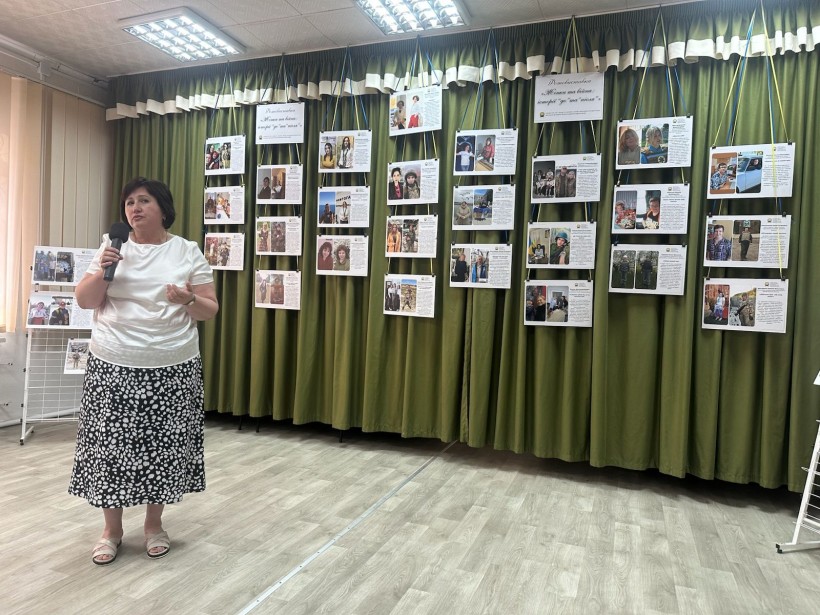 Представниця Селидівської  громади виступає з промовою на фоні експозиції фотовиставки.