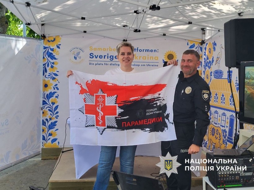 Представники делегації Донеччини тримають прапор парамедиків