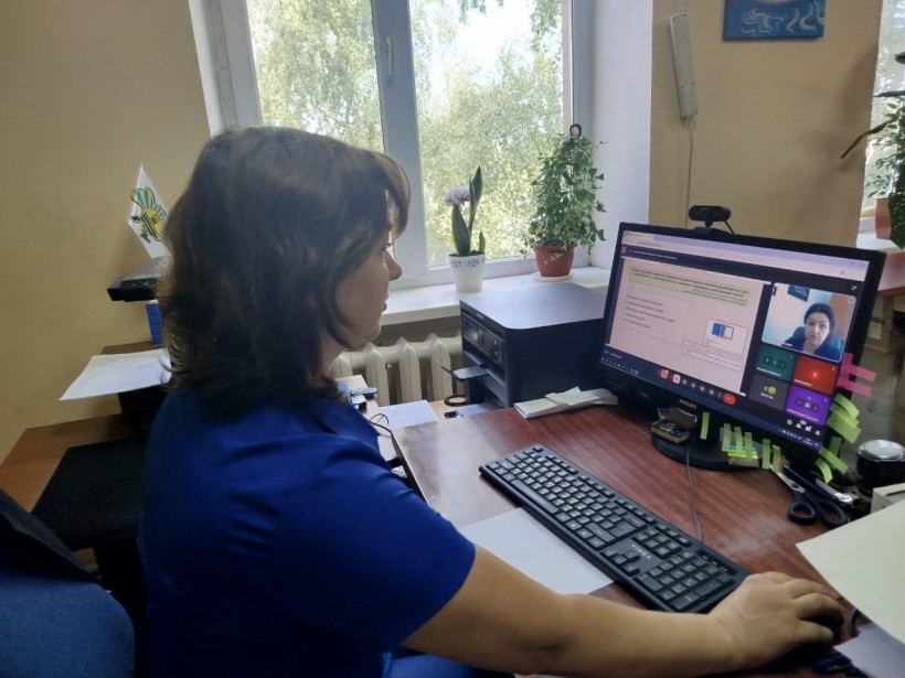 Представник військової адміністрації сидить за столом та слухає доповідача на семінарі
