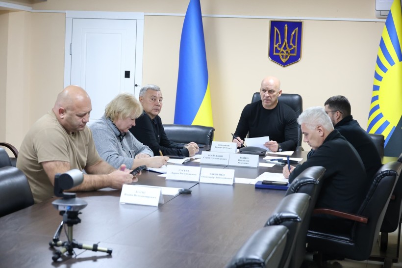 Учасники наради сидять за столом