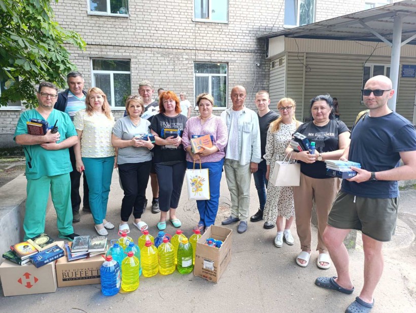 Спільне фото захисників та захисниць разом з представниками Мирноградської громади з книжками, буклетами та гігієнічними наборами.