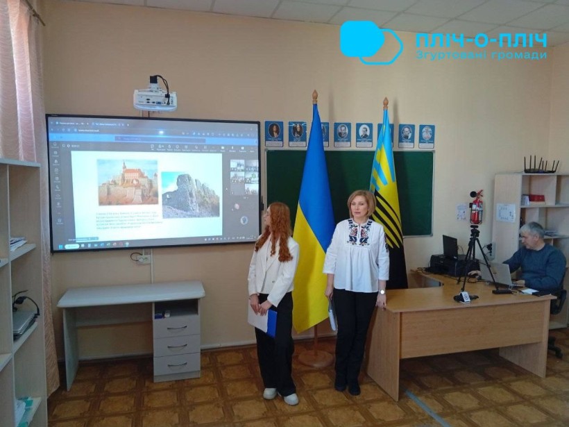 Учасниці заходу стоять у вишиванках біля лед-екрану на якому показують презентацію міста Покровськ.