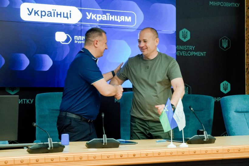 Керівники громад тиснуть руки після підписання меморандуму про співпрацю