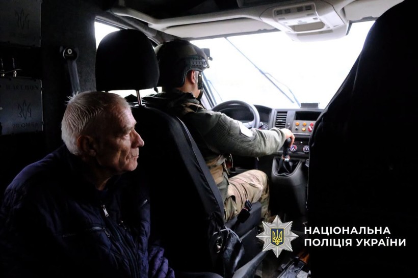 Поліцейський за кермом евакомобіля, де сидить дідусь