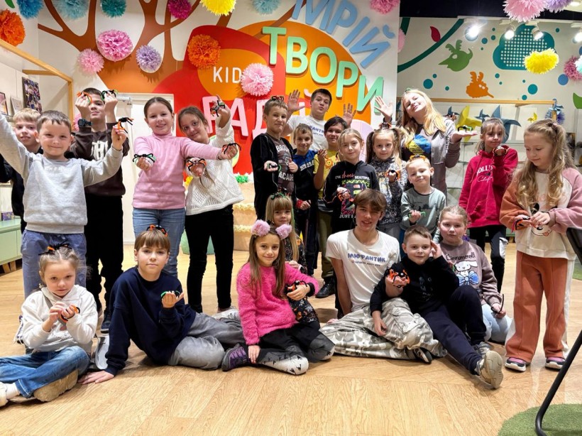 Юні гості хабу на груповому фото демонструють поробки з пряжі у вигляді комах