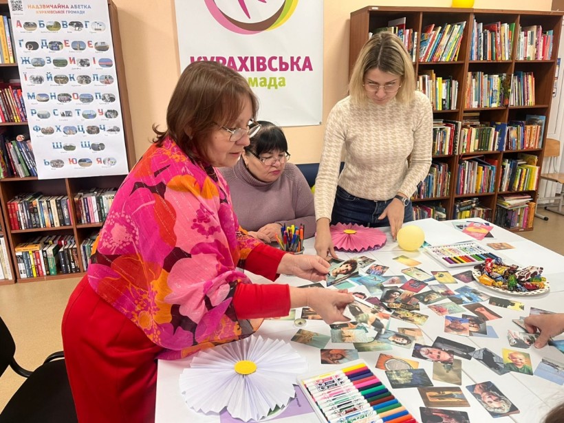 Учасники психологічного заняття працюють за столом, виконуючи арт-терапевтичні вправи