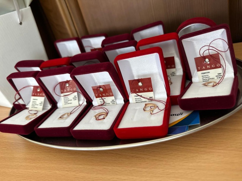 Пам’ятні подарунки для випускників Бахмутської громади: золоті кулони у формі серця та інших символів, упаковані в оксамитові футляри.