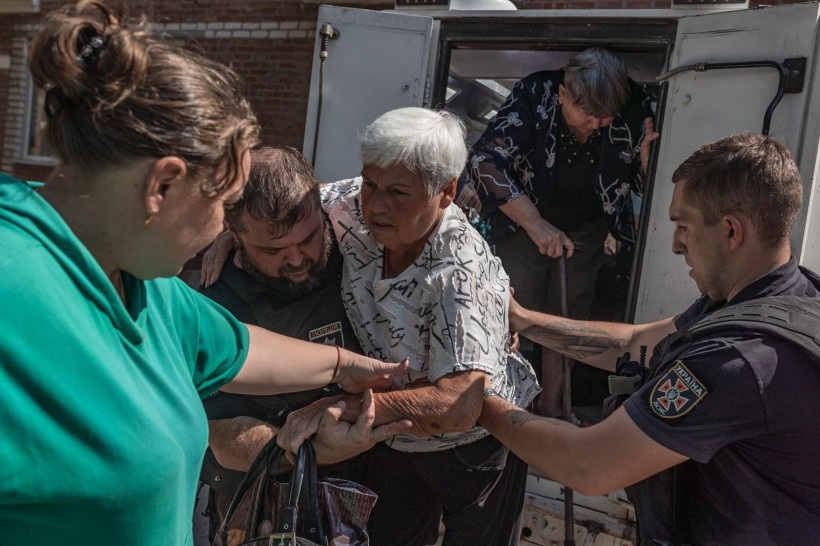 Маломобільну жінку евакуюють співробітники поліції та ДСНС